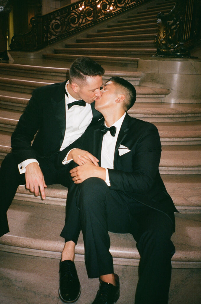 Grooms sitting on stairs of SF City Hall.