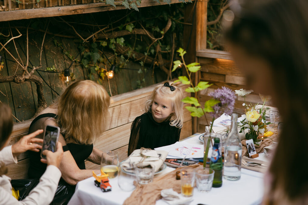 Little girl coloring and sitting at the wedding reception.