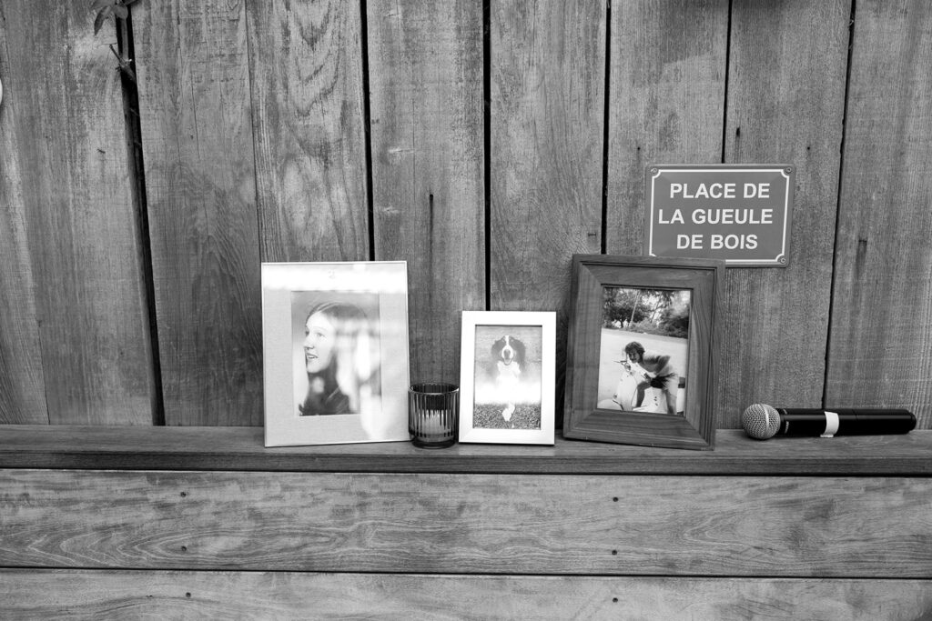 Framed photos of family and loved ones on a wooden ledge.