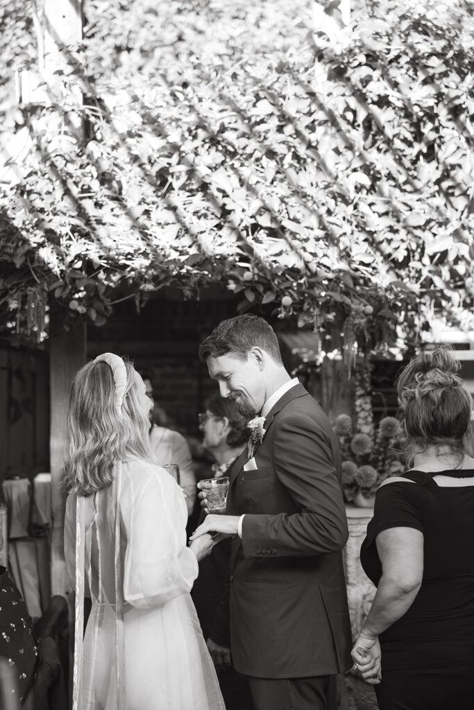 Candid photo of the bride and groom holding hands and giggling together at reception.