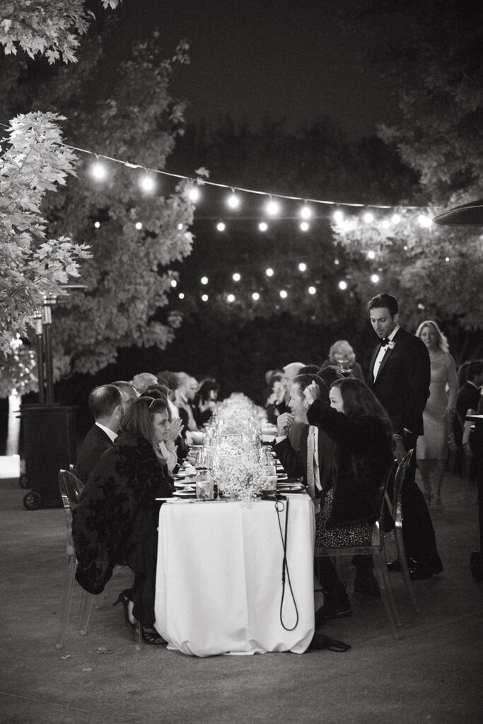 Night time photo of the wedding reception tablescape as guests are seated.