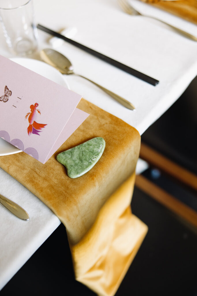 Wedding tablescape with mustard yellow velvet napkin and a green guasha on top with a custom purple menu card on the plate.