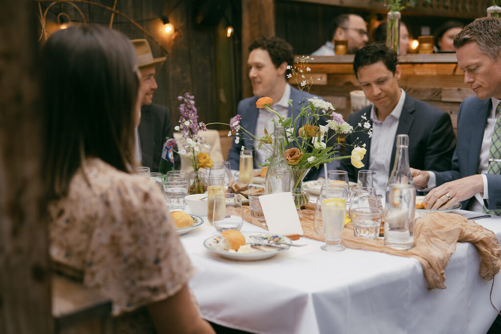 Wedding guests sitting around the table chatting.
