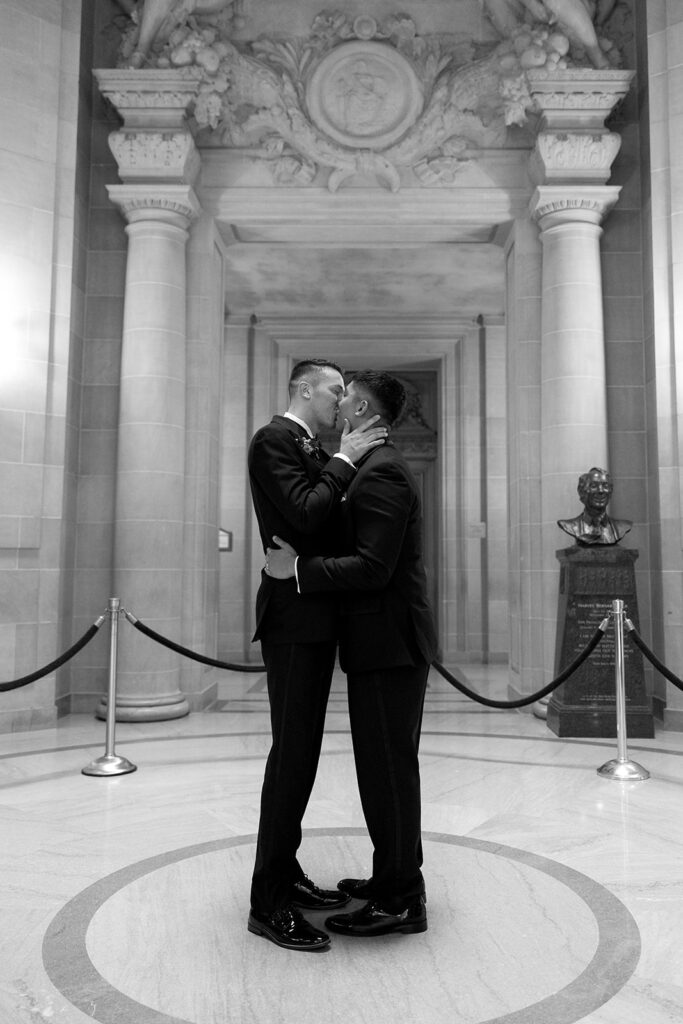 Grooms kissing after saying I Do at SF City Hall wedding ceremony.