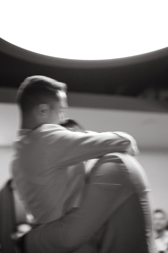 Blur motion photo of grooms holding each other and hugging.