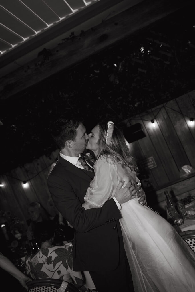 Bride and groom kissing at reception.
