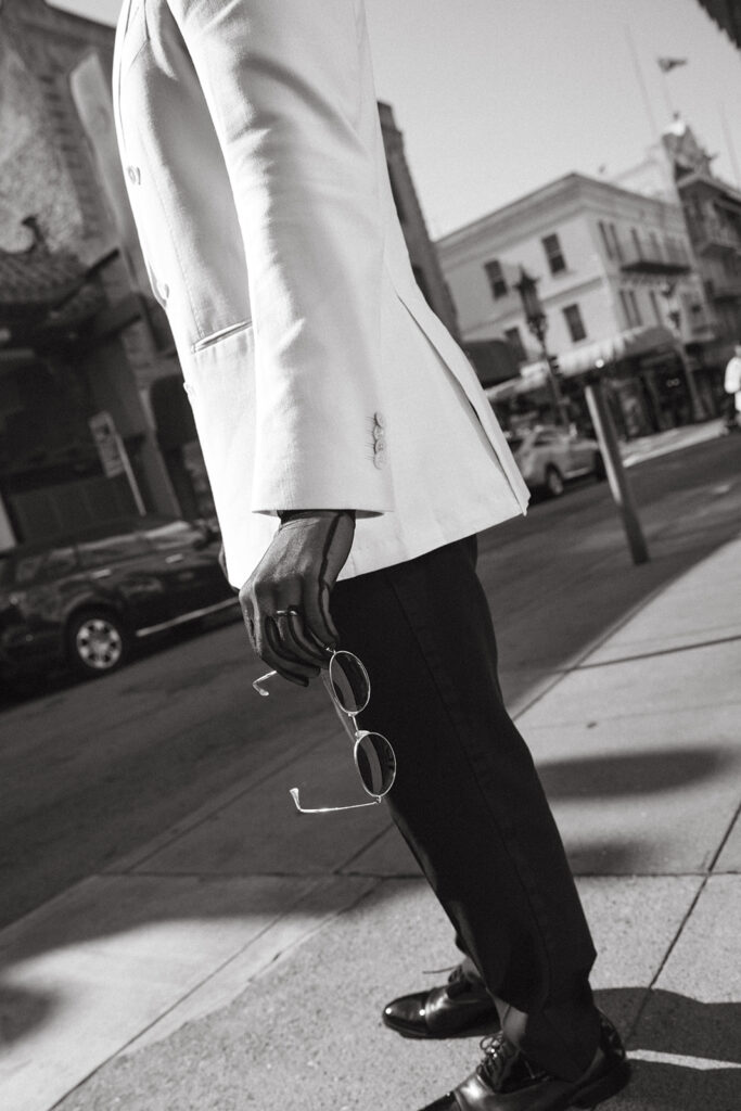 Man with a mesh black glove holding a pair of sunglasses.