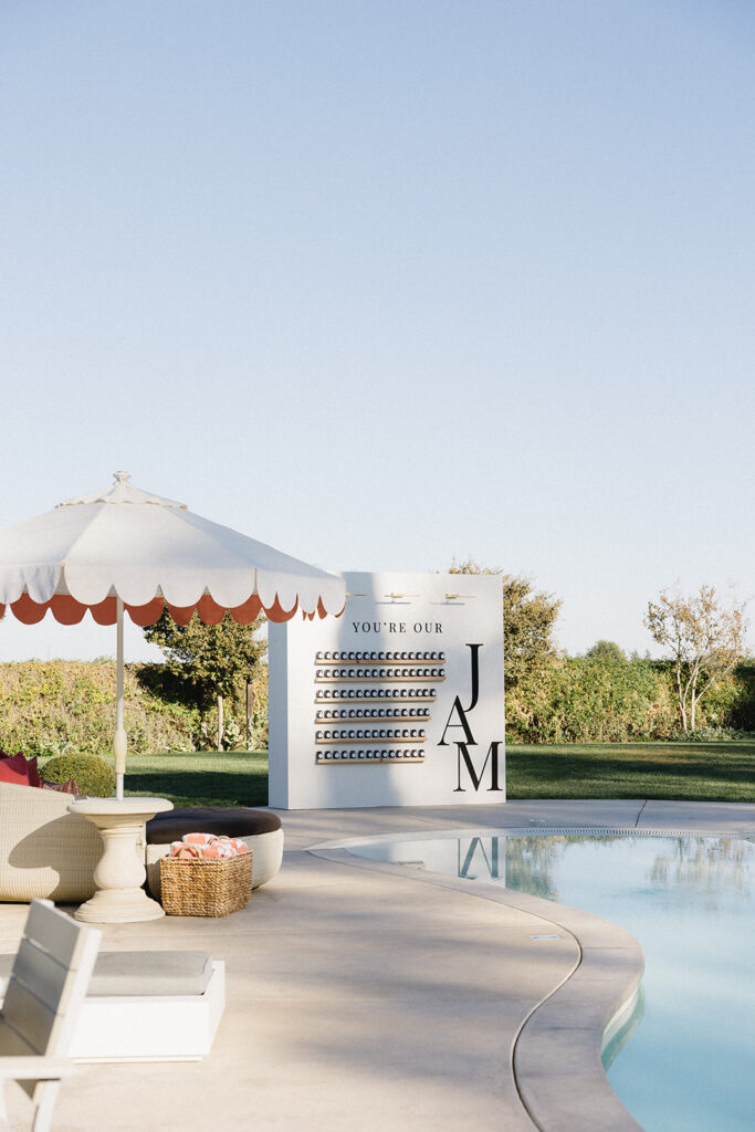 Large sleek seating chart installment next to a pool with large letters JAM.