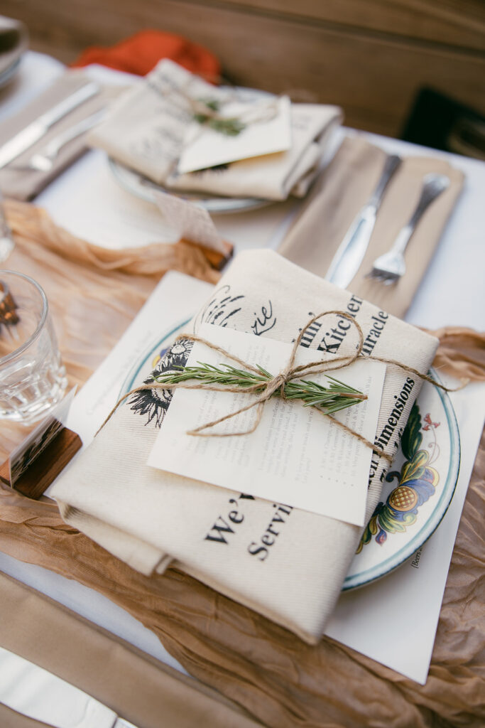 Tablescape table setting with rosemary garnish tied in with jute string.