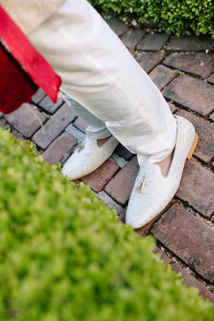 Grooms white formal shoes with gold accents.
