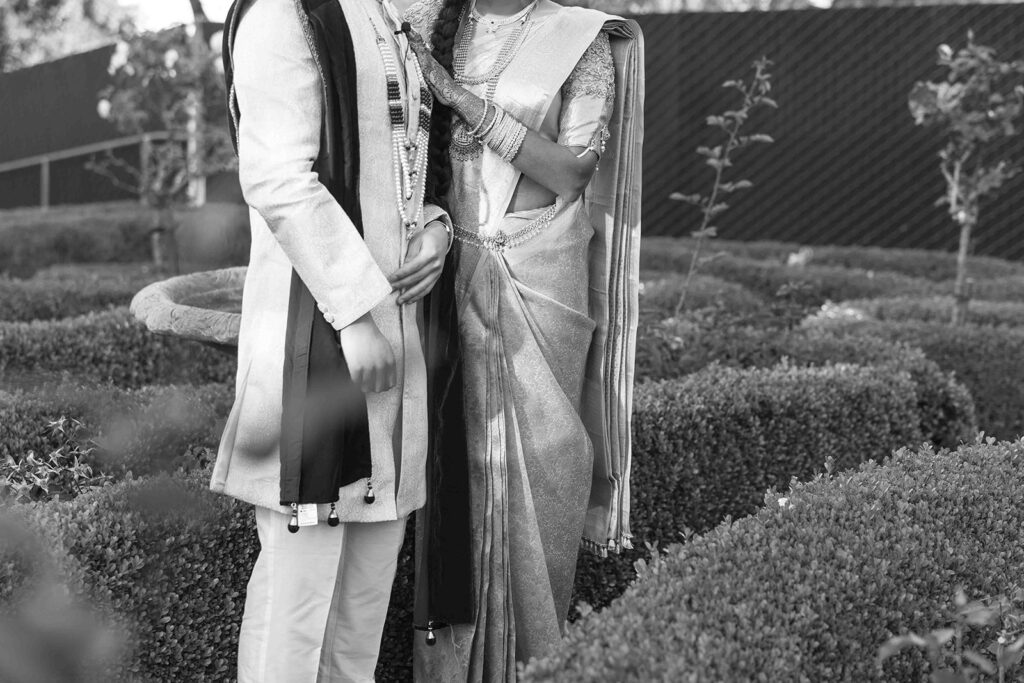 Detail shot of the brides saree and the grooms sherwani and dupatta in black and white.