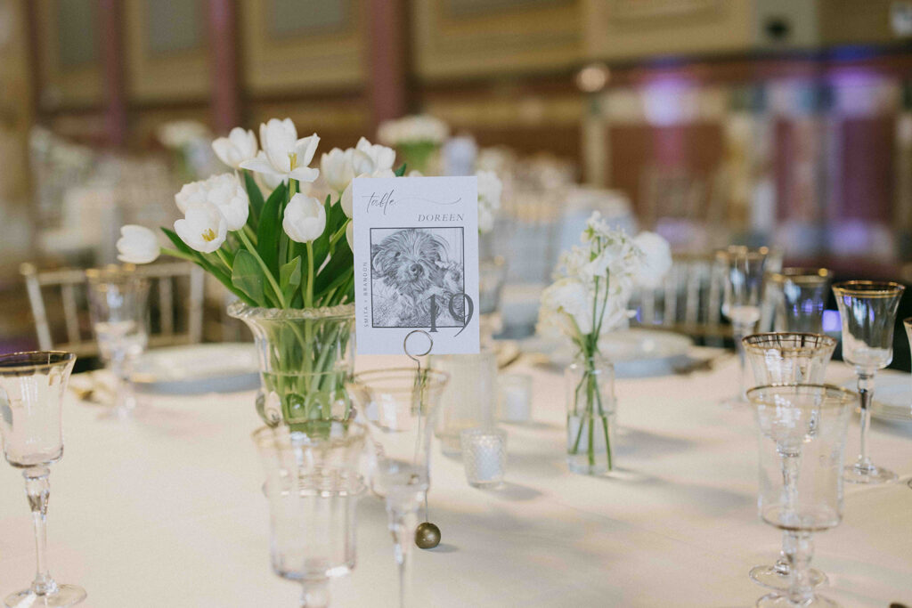 Table name card of a black and white hand drawn photo of a dog named doreen.