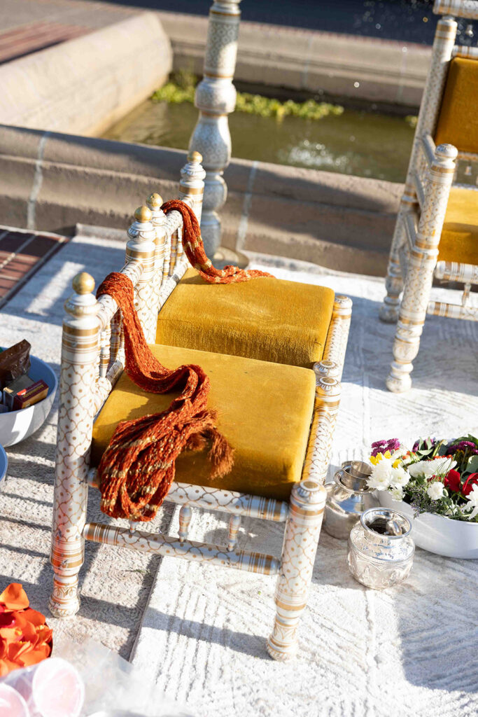 Ornate mustard yellow chairs at altar for wedding ceremony.