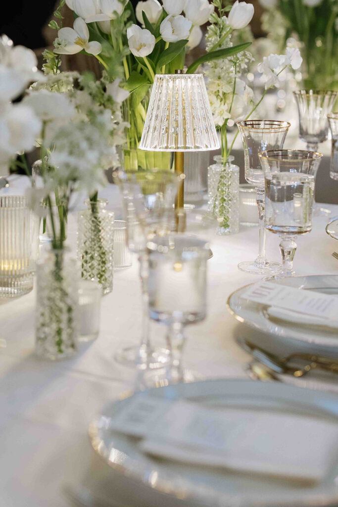 All white wedding reception tablescape with gold and crystal table lights.