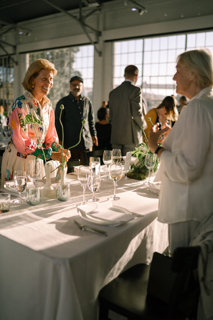 wedding guests arriving at their seats smiling at one another