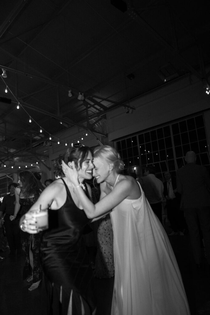 Bride laughing with a friend while holding her head