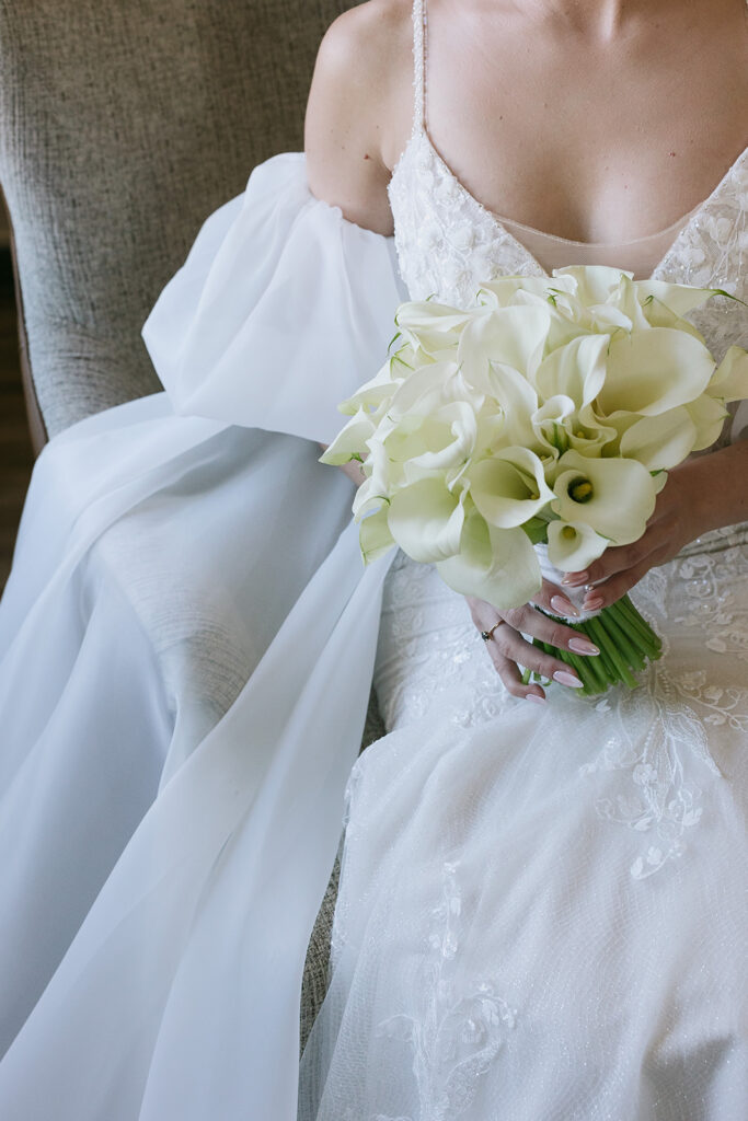 Bride holding white lily bouquet with her almond wedding nails