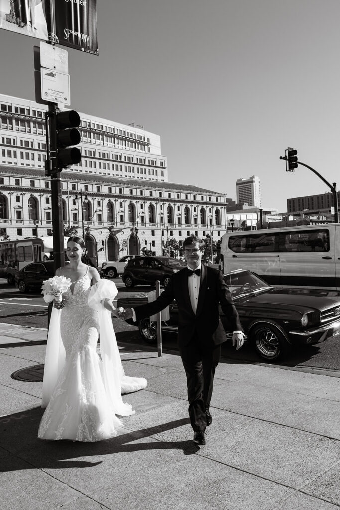 bride and groom walking away from the street that has a vintage parked mustang behind them