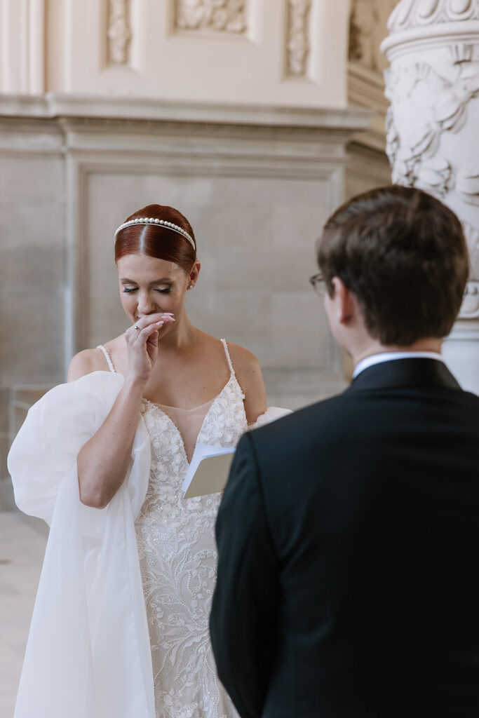 Bride getting choked up during wedding ceremony as she reads her vows