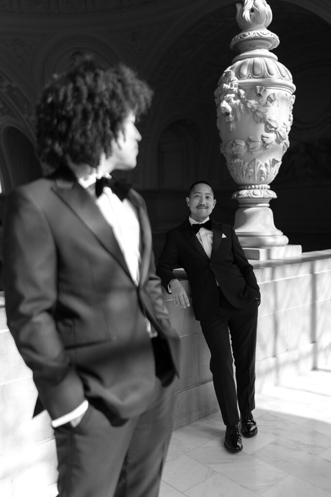 Groom smiling at his husband in front of him out of focus