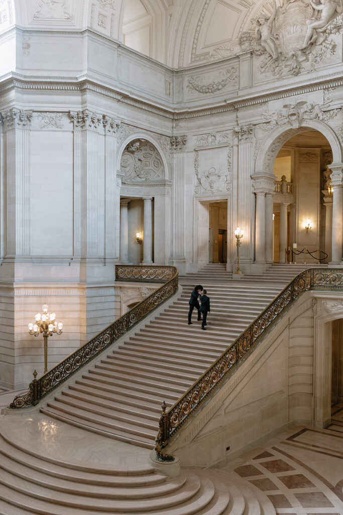 Grooms walking up the stairs of SF city hall